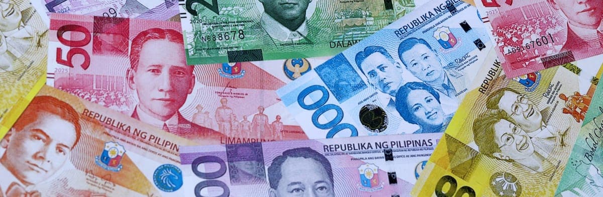 Philippine peso banknotes in several denominations, spread out and overlapping